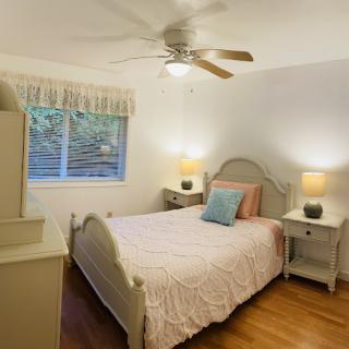 A cozy and inviting bedroom featuring a light-colored bed, soft bedding, and warm lighting.
