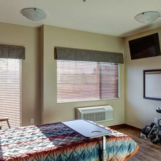 A hospital room featuring a bed, television, and medical equipment.