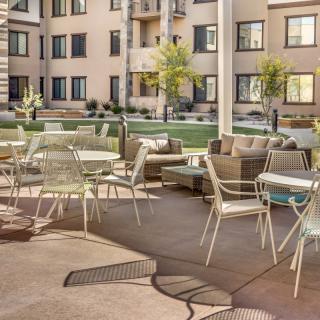 A modern outdoor seating area with tables and chairs in an apartment complex.