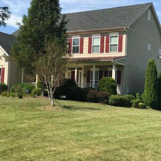 A suburban home with a well-maintained lawn and surrounding trees.