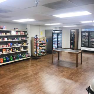 A small grocery store with shelves and refrigerators.