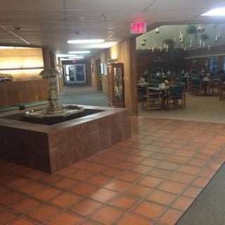 A hallway with a decorative fountain and visible restaurant seating area.