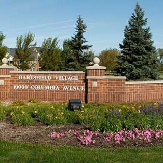Entrance sign for Parkside Village surrounded by a landscaped area with flowers and trees.