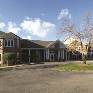 A large building with a prominent entrance under a partly cloudy sky.