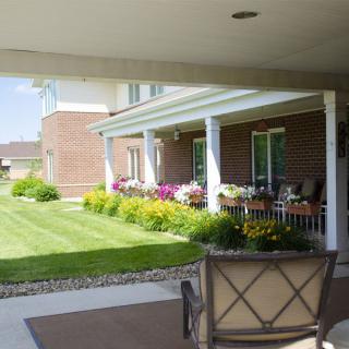 A well-maintained yard featuring a porch and colorful flower beds.