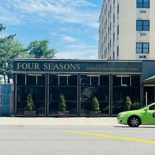 The Four Seasons restaurant showcasing its welcoming facade amidst a lively urban setting.