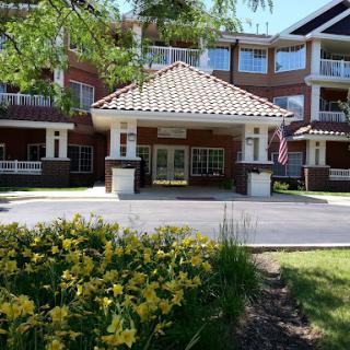 A welcoming entrance to a residential building surrounded by blooming flowers.
