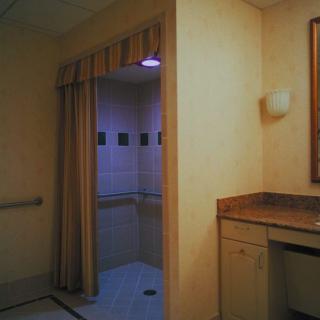 An accessible bathroom with a curtained shower area and a sink.