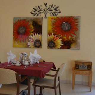A cozy dining room featuring floral artwork and an inviting table setting.