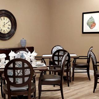 A cozy dining room with elegant table settings and wall decor.