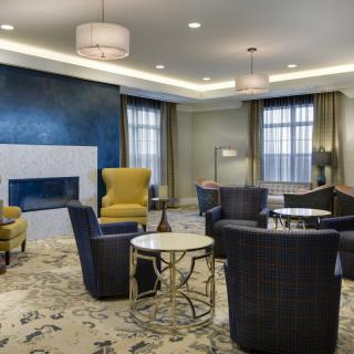 A modern living room featuring comfortable seating around a fireplace with stylish lighting.