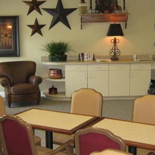 A cozy room with tables and chairs arranged for a casual setting, complemented by decorative elements like wall stars and a lamp.