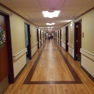 A long hospital corridor with doors on either side.