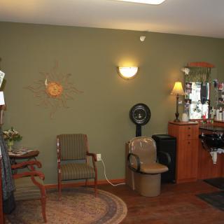 A cozy salon interior with seating and a hair styling station.