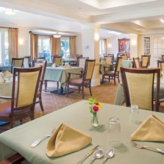 A spacious and elegantly arranged restaurant dining room with neatly set tables.