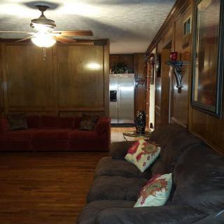 A cozy living room with wood paneling and comfortable sofas.