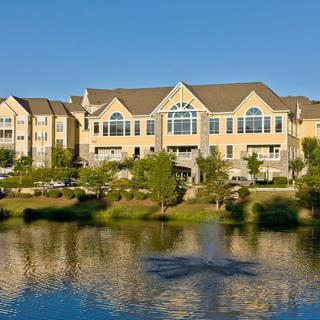 A residential building with a scenic lake view reflecting the clear blue sky.