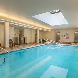 An indoor swimming pool with a skylight, providing a relaxing and enjoyable space for guests.