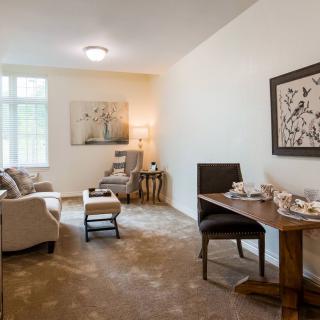 A cozy living room with a comfortable sofa, artwork on the walls, and natural light streaming through the windows.