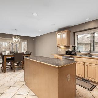 A modern kitchen with a center island and adjacent dining area.