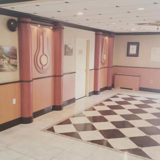 An interior hallway with checkered flooring and decorative wall elements.