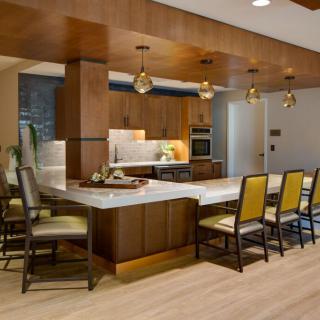 A modern kitchen with a central island, featuring wood accents and stylish pendant lighting.