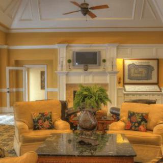 A cozy and elegant living room featuring a fireplace, sofa set, and a coffee table with decorative items.