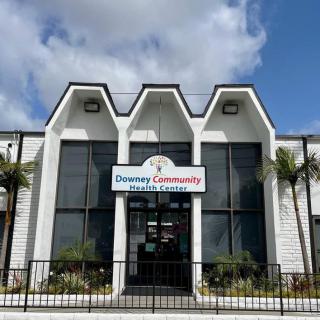 A community center building with a modern architectural design and palm trees in front.