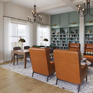A stylish living room with leather chairs, bookshelves, and chandeliers creating a cozy reading area.