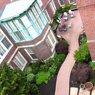 A well-maintained courtyard with brick pathways and garden landscaping.