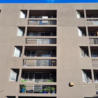 A view of a multi-story apartment building featuring multiple balconies and windows.