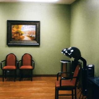 A cozy salon waiting area with chairs and hair dryers.