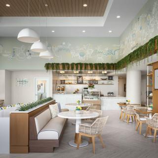 A modern cafe interior with cozy seating and greenery decor.