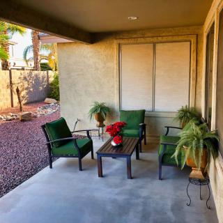 Cozy patio with chairs, a table, and potted plants.