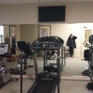 A glimpse of a gym featuring a treadmill and fitness equipment in an indoor setting.