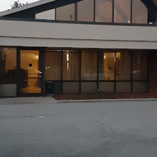A modern building featuring a glass facade, captured during the evening hours.