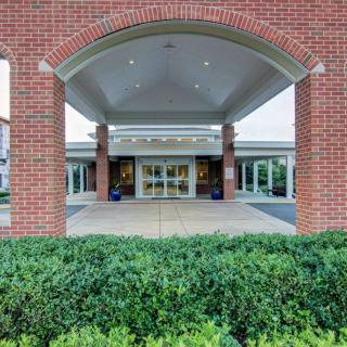 A symmetrical brick building entrance with a landscaped foreground.