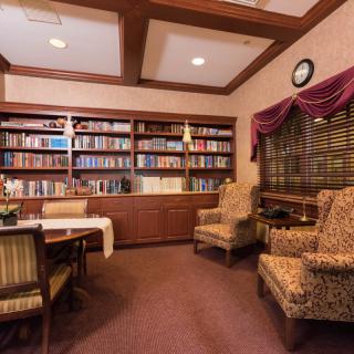 A cozy library with bookshelves and a seating area.