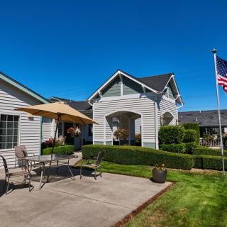 A suburban house with a patio set and an American flag on a clear day.
