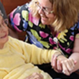 A caregiver provides support and companionship to an elderly person.