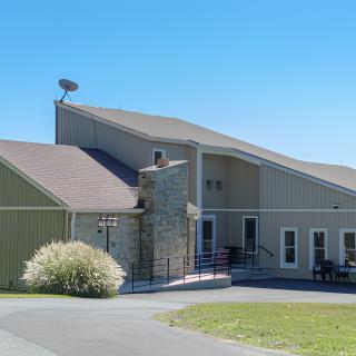 A modern suburban building with a sloped roof and a stone facade on a clear day.