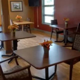 A cozy dining area with neatly arranged tables and chairs, featuring a warm decor.