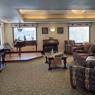 A cozy living room with a piano and comfortable seating.