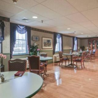 A spacious dining room with tables and chairs arranged neatly by the windows.
