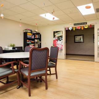 A cozy meeting room with a round table, comfortable chairs, and decorative elements.