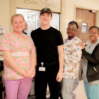A group of medical staff members posing together in a hospital setting, showcasing teamwork and camaraderie.