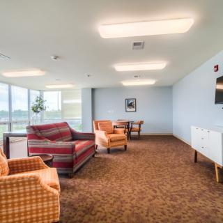 Spacious living room with comfortable seating arrangements and large windows.