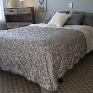 A cozy bedroom with a neatly made bed and decorative pillows.