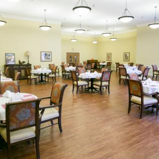 An elegant and empty dining room with neatly set tables and chairs.