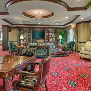 A luxurious library and living room area with opulent furnishings and decor.